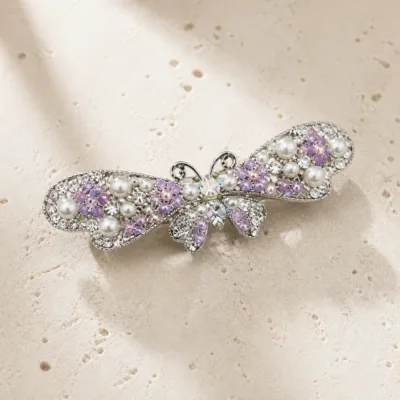 Gancho borboleta com pérolas e strass multicolor sobre pedra bege