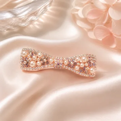 Gancho rosa-dourado em laço com pérolas sobre cetim rosa