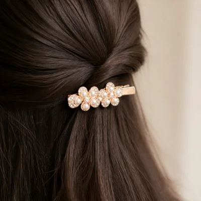 Gancho rosa-dourado com flores aplicado no cabelo