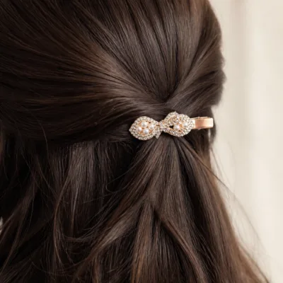 Gancho rosa-dourado infinito aplicado no cabelo