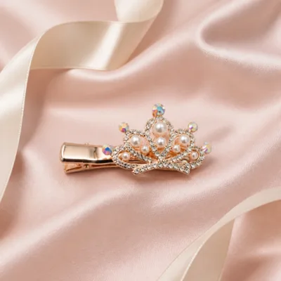 Gancho rosa-dourado com pérolas sobre cetim rosa