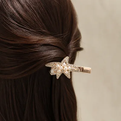 Gancho rosa-dourado com pérolas aplicado no cabelo