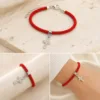 Pulseira vermelha com cruz prateada de cristais