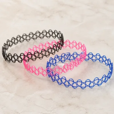 Detalhe do padrão entrelaçado das pulseiras tattoo preta, rosa e azul