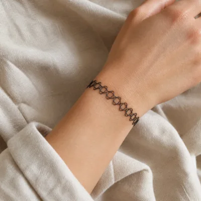 Pulseira elástica tattoo preta usada no pulso