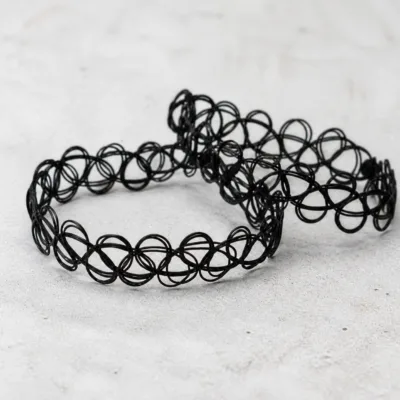 Detalhe do padrão de laços entrelaçados da pulseira tattoo preta