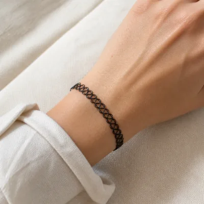 Pulseira elástica tattoo preta usada no pulso