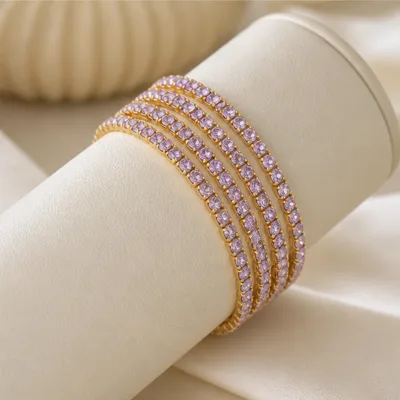 Quatro pulseiras finas douradas num expositor de joalharia