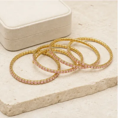 Pulseiras douradas com cristais rosa em composição elegante