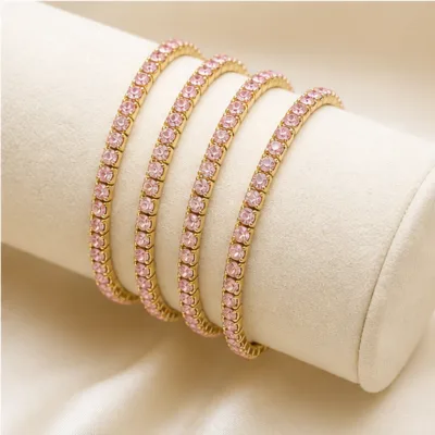 Quatro pulseiras finas douradas num expositor de joalharia