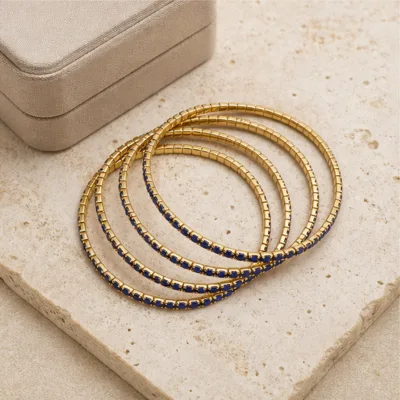 Pulseiras douradas com cristais azuis em composição elegante