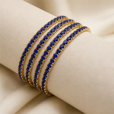 Quatro pulseiras douradas com cristais azuis num expositor