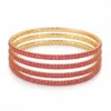 Conjunto de quatro pulseiras douradas com cristais rosa vivo