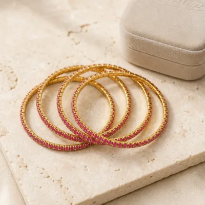 Pulseiras douradas com cristais rosa em composição elegante