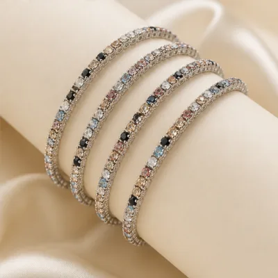 Quatro pulseiras prateadas multicolor num expositor