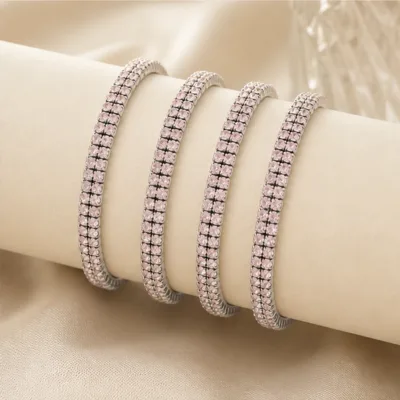 Quatro pulseiras prateadas com cristais rosa-claro num expositor