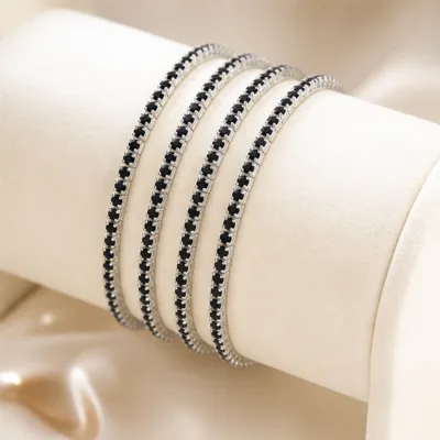 Quatro pulseiras prateadas com cristais pretos num expositor