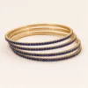 Conjunto de quatro pulseiras douradas com cristais azul-royal