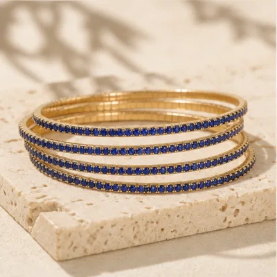Pulseiras douradas com cristais azul-royal numa composição elegante