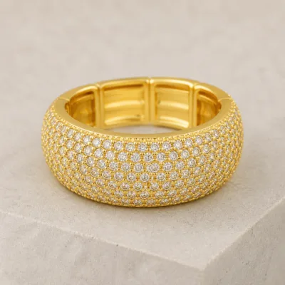 Anel largo dourado elástico com várias filas de pequenas zircónias brancas