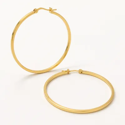 Par de argolas douradas de 70 mm numa composição de seda neutra