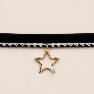 Detalhe da renda branca, estrela dourada e pequena pérola