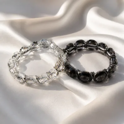 Pulseiras de vidro oval transparente e preto sobre cetim