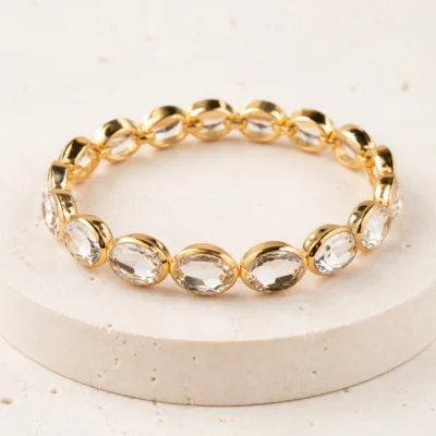 Pulseira dourada com pedras ovais de vidro transparente
