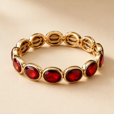 Pulseira dourada com pedras ovais de vidro vermelho