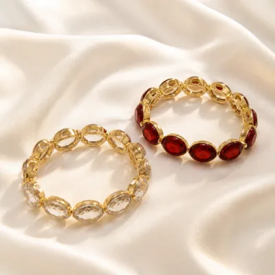 Pulseiras douradas de vidro transparente e vermelho sobre cetim