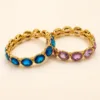 Pulseiras douradas de vidro oval azul e roxo