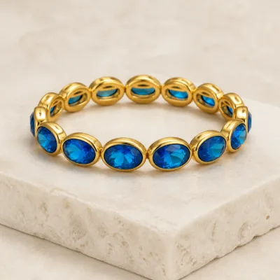 Pulseira dourada com pedras ovais de vidro azul