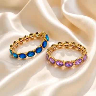 Pulseiras douradas de vidro azul e roxo sobre cetim