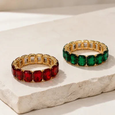 Pulseiras vermelha e verde com cristais retangulares sobre base clara