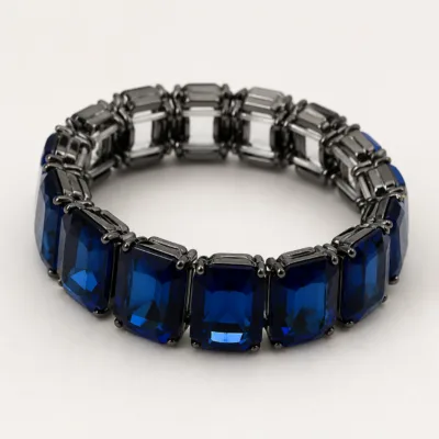 Pulseira azul-safira com cristais retangulares sobre pedra clara