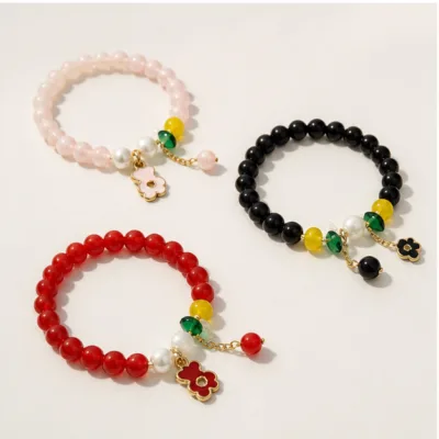 Seleção de pulseiras de contas rosa, preta e vermelha com flor
