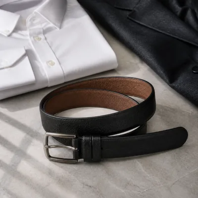 Cinto de couro preto com fivela prateada em composição de roupa formal