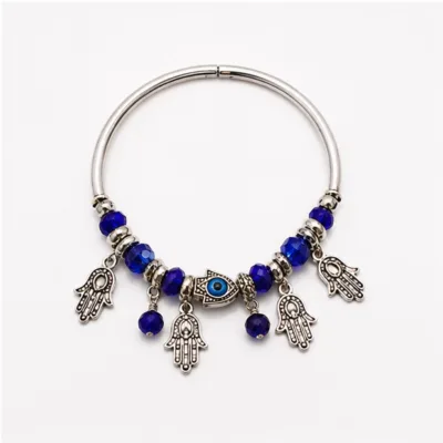 Pulseira de aro prateado com olho azul e pendentes de mãos da sorte