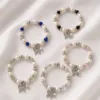 Cinco modelos de pulseira de pérolas e cristais com borboleta