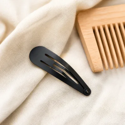 Gancho de cabelo preto sobre tecido claro