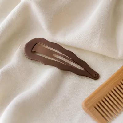 Gancho ondulado castanho sobre tecido claro