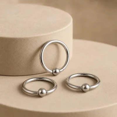 Detalhe do piercing de septo prateado com esfera