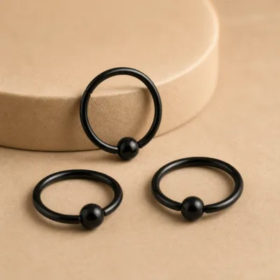 Detalhe do piercing de septo preto com esfera
