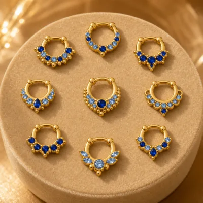 Detalhe dos piercings de septo dourados com zircónias azuis