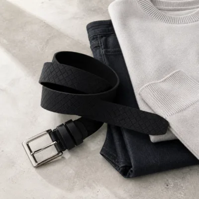 Cinto preto entrançado em composição casual com ganga e malha