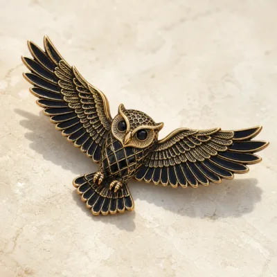 Alfinete de coruja preto e dourado em detalhe