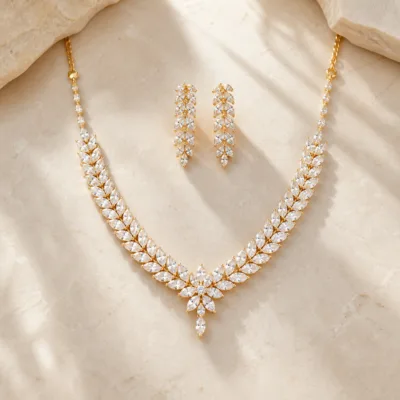Conjunto dourado de colar e brincos com folhas de zircónia