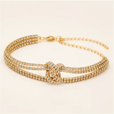 Pulseira dourada de zircónias com nó entrelaçado