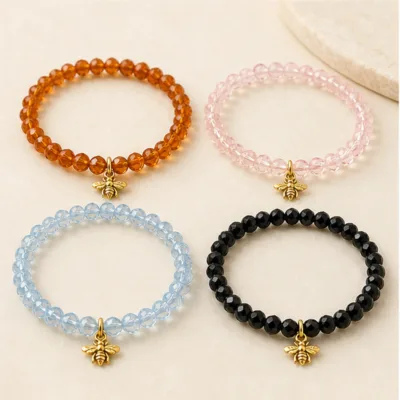 Pulseiras laranja, rosa, azul-gelo e preta com abelha dourada