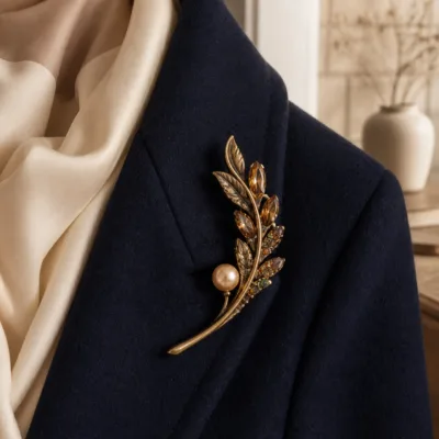Alfinete ramo âmbar com pérola sobre blazer azul-marinho